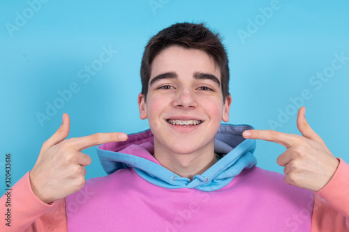 portrait of young teenage girl isolated showing braces and orthodontics photo
