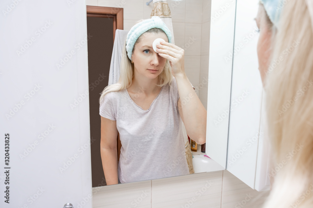 Morning and evening routine for woman, she cleansing her face with a cotton pad and face lotion to remove dirt and make-up, facial care concept Morning and evening routine for woman, she cleansing her face with a cotton pad and face lotion to remove dirt and make-up, facial care concept