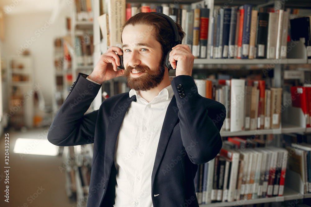 Man in a library. Guy in a black suit. Student with a books. Man in a library. Guy in a black suit. Student with a books.