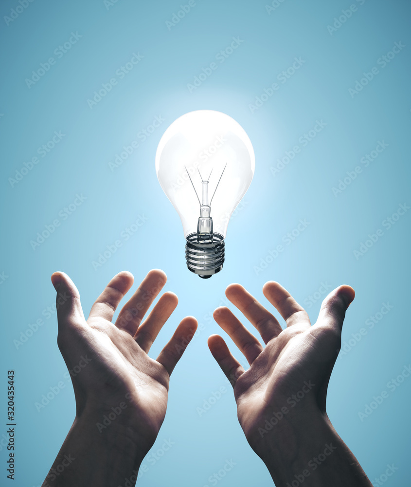 Hands holding bulb on blue background - obrazy, fototapety, plakaty 