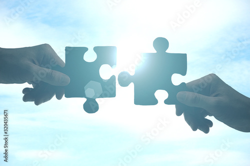 Hands putting puzzle pieces together photo