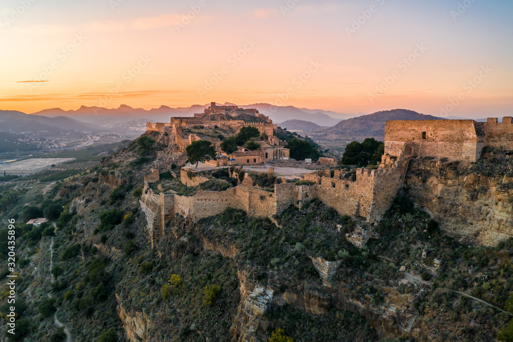 Aerial sunset view of Sagunto, huge fortress stretching across the mountain range north of Valencia Spain