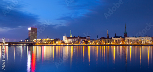 Panorama of Old Riga in Latvia  Europe  view of Presidential Castle  promenade with city lights reflecting over the river of Daugava  night view  twilight  banner