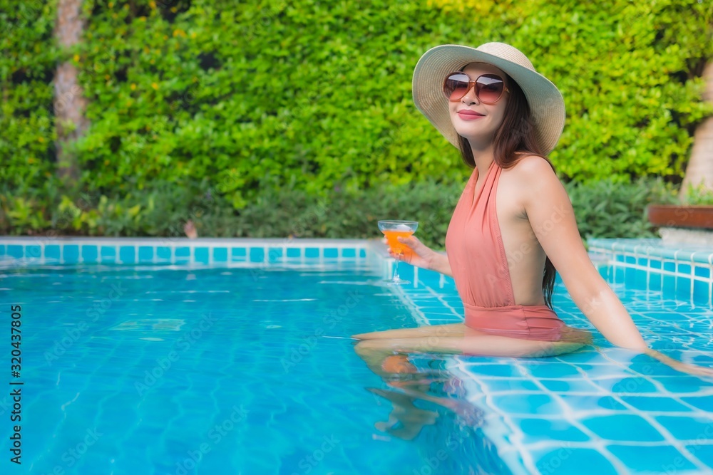 Portrait young asian woman relax happy smile around swimming pool in hotel