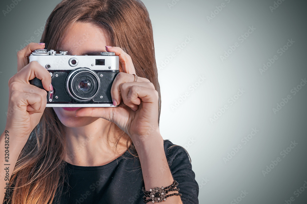 Close up portrait of a smiling pretty girl in dress taking photo on a retro camera Close up portrait of a smiling pretty girl in dress taking photo on a retro camera