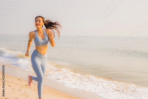 Portrait sport young asian woman prepare exercise or run on the beach sea ocean