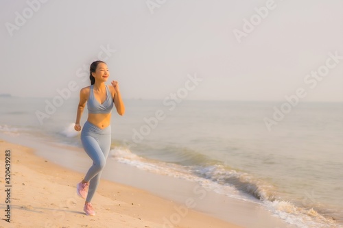 Portrait sport young asian woman prepare exercise or run on the beach sea ocean