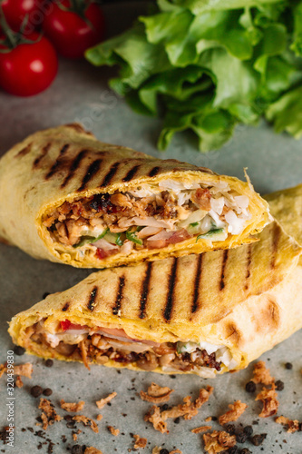 Shawarma sandwich gyro fresh roll of lavash pita bread chicken beef shawarma falafel RecipeTin Eatsfilled with grilled meat, mushrooms, cheese. Traditional Middle Eastern snack. On wooden background