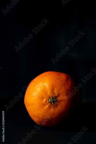 orange Mandarine auf schwarzem Grund mit weißraum