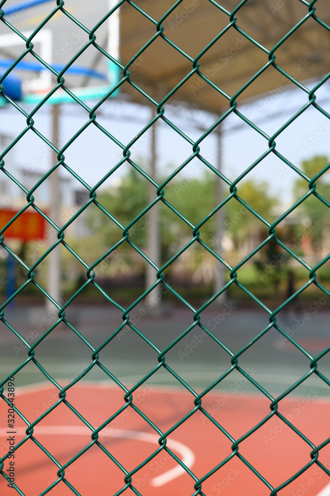outdoor basketball court behind a metal fence vertical composition outdoor basketball court behind a metal fence vertical composition
