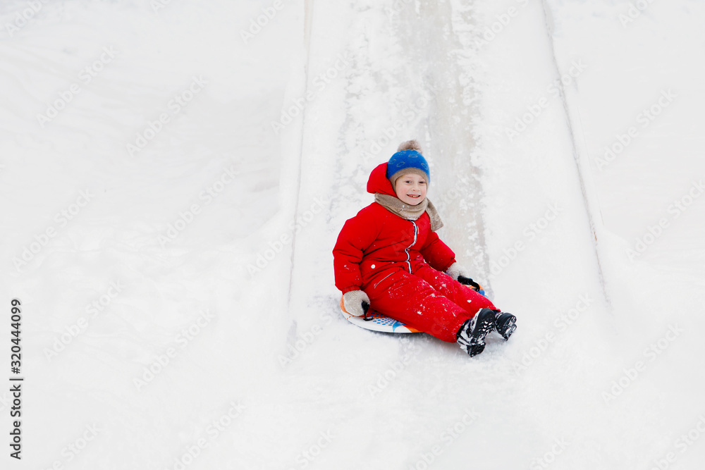 Child slide downhill an ice hill