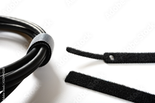 Bild auf Leinwand black velcro cable tie and cable on white