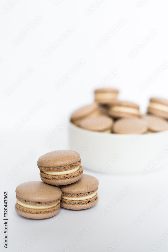 Coffe macaron in a white plate on a white isolated background