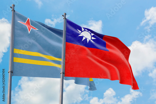 Taiwan and Aruba flags waving in the wind against white cloudy blue sky together. Diplomacy concept, international relations.