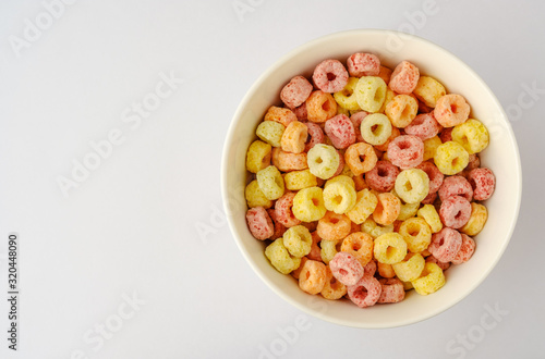 Cereal flakes in bowl with copy space,Breakfast concept.Food with delicious fruity taste and fruity colours.It's made with maize,wheat,and barley.topview and copy space.white background