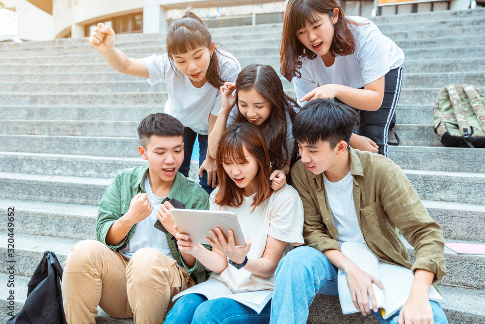 Group of students studying on the stairs at campus Group of students studying on the stairs at campus