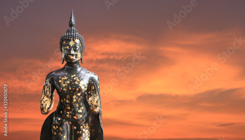 Buddha statue on twilight sky background.