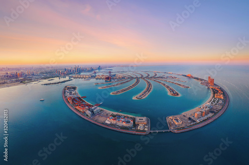 Aerial view of The Palm Jumeirah Island, Dubai Downtown skyline, United Arab Emirates or UAE. Financial district and business area in smart urban city. Skyscraper and high-rise buildings at sunset.