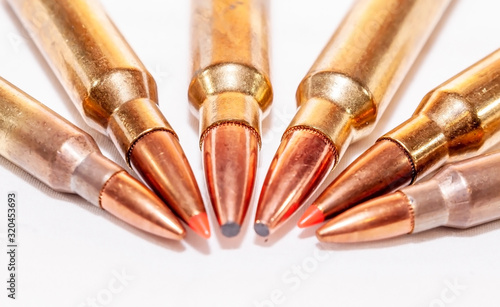 Six rifle bullets, two each of different calibers on a white background