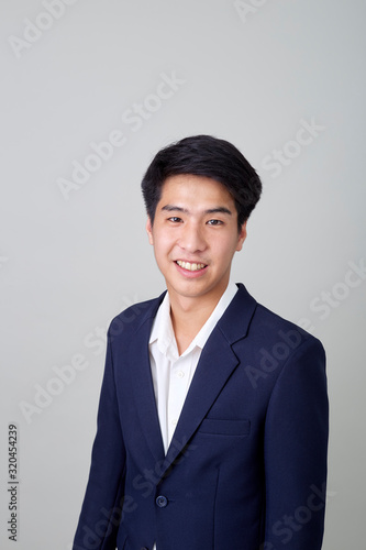 Portrait of fashionable asian businessman on bright gray