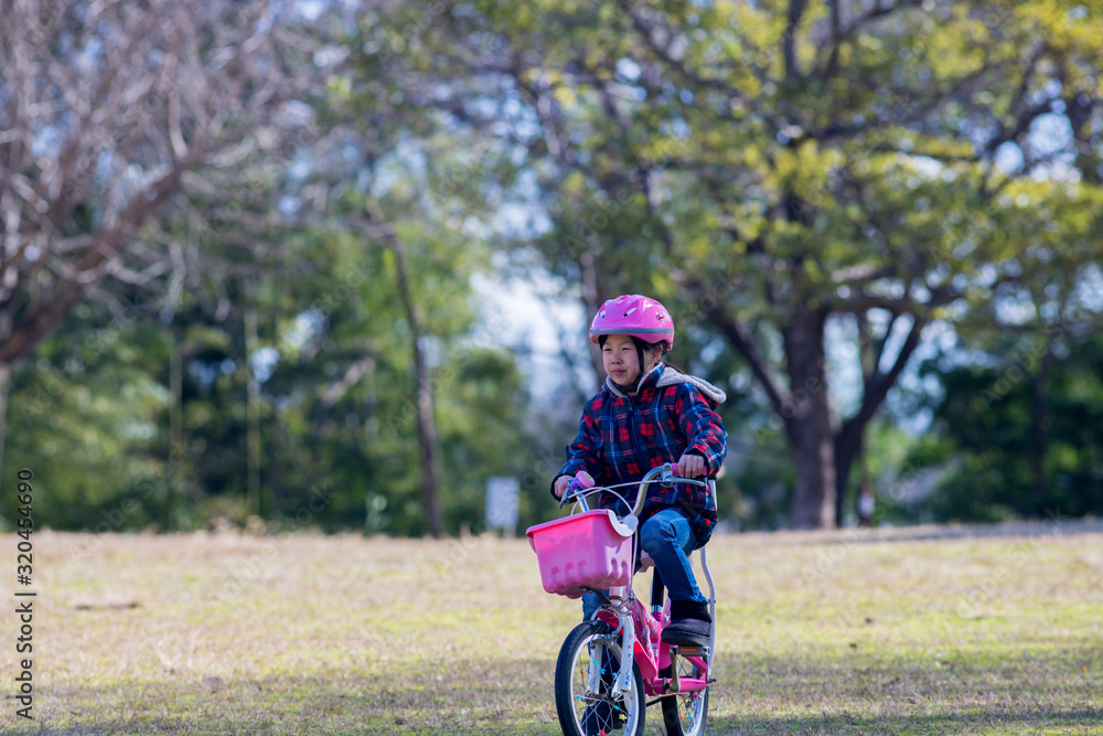 冬の公園で自転車を乗って子供 冬の公園で自転車を乗って子供