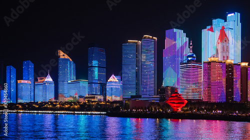 Scenic night view from the Urban park new town seaside of Qingdao, China.Seaside tourist town that is popular with Chinese people.Building lighting show With beautiful color lights at night.