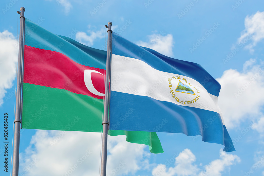 Nicaragua and Azerbaijan flags waving in the wind against white cloudy blue sky together. Diplomacy concept, international relations. Nicaragua and Azerbaijan flags waving in the wind against white cloudy blue sky together. Diplomacy concept, international relations.