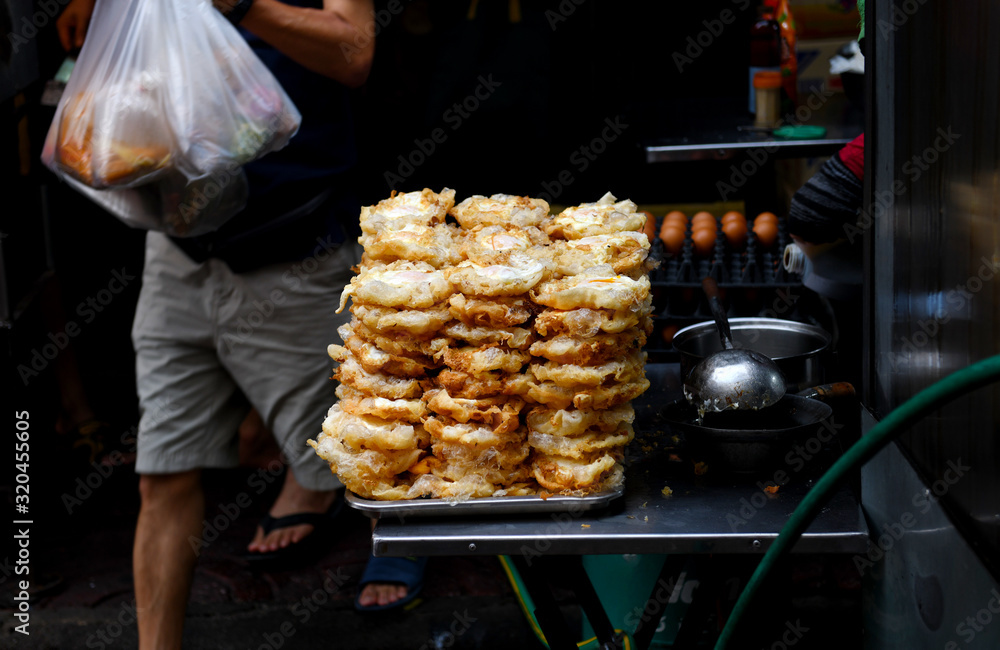 Fried egg is cooked and then stacked into piles to lead to a roadside restaurant in Chinatown. Bangkok, Thailand