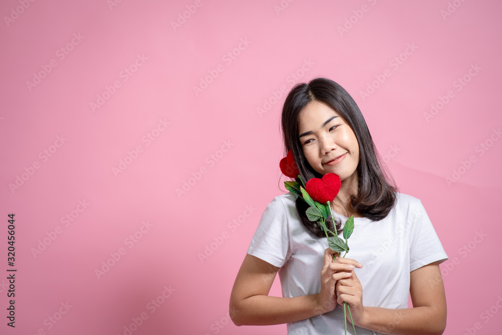 Beautiful girl, cheerful girl model with beauty, a valentine shaped cookie in her hand Love concept Beautiful smiling woman Valentine's day gift Isolated on a pink background Beautiful girl, cheerful girl model with beauty, a valentine shaped cookie in her hand Love concept Beautiful smiling woman Valentine's day gift Isolated on a pink background