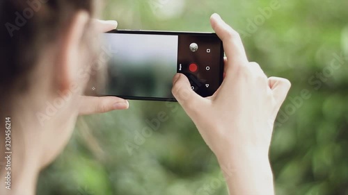 Young woman photographs nature on the phone