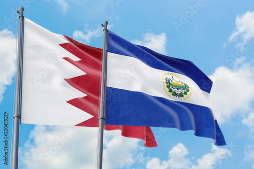 El Salvador and Bahrain flags waving in the wind against white cloudy blue sky together. Diplomacy concept, international relations.