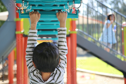 boy climbing monkey bars at playground
