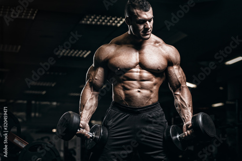 Muscular man bodybuilder training in gym and posing. Fit muscle guy workout with weights and barbell © Fotokvadrat