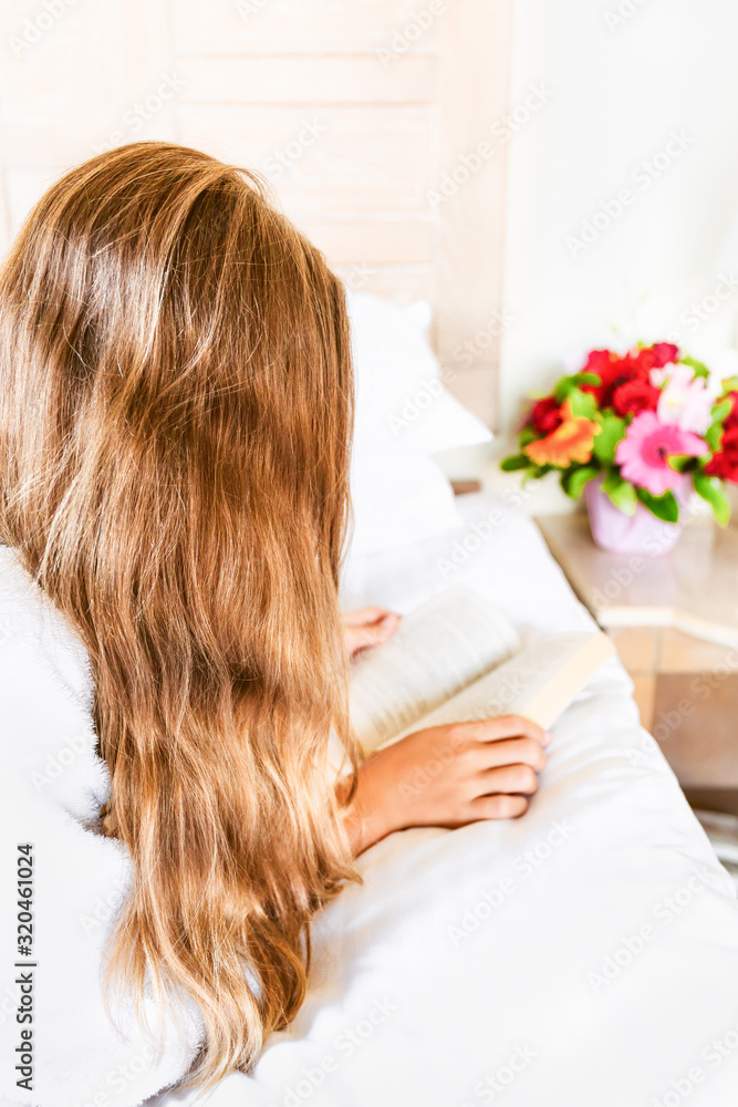 Girl relaxing in her hotel room: reading a book. Vacation, relaxation, self time and getaway concepts. Vertical Girl relaxing in her hotel room: reading a book. Vacation, relaxation, self time and getaway concepts. Vertical