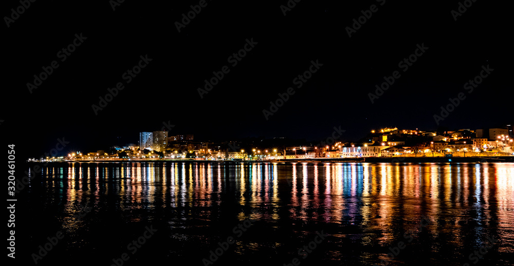 Panorama ofPorto city at night, reflection of shadows in water