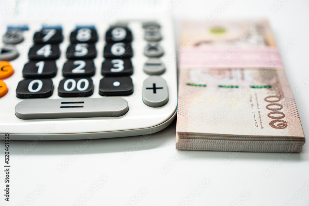 Close up calculator and 1000 Thai Bath currency money banknote. Background concept for thailand financial and economy. Close up calculator and 1000 Thai Bath currency money banknote. Background concept for thailand financial and economy.