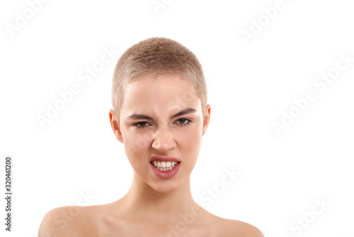 Emotional girl. Portrait of attractive half-naked blond woman with short hair looking at camera and making angry face while standing against white background. Snarling at the camera.