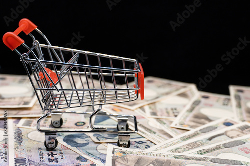 Close up japanese currency yen money banknote in small shopping trolley . Background concept for japan economy and online market.