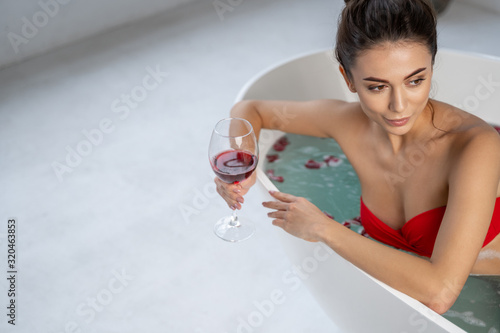 Girl sitting in a bathtub with rose petals
