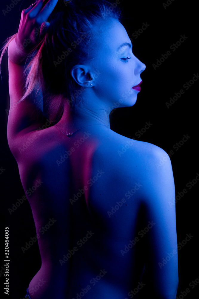 High Fashion model woman in colorful bright lights posing in studio, portrait of a beautiful girl. Artistic colorful design. Party concept, stands with his back High Fashion model woman in colorful bright lights posing in studio, portrait of a beautiful girl. Artistic colorful design. Party concept, stands with his back
