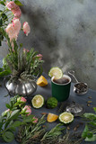 Aromatic hot herbal tea with slice of bergamot in ceramic cup. Assortment of herbs and citrus fruits for making tea. home gardening concept. Copy space, vertical banner