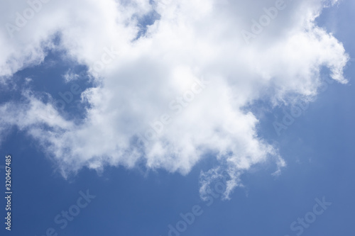 Blue sky background and white clouds passing by.