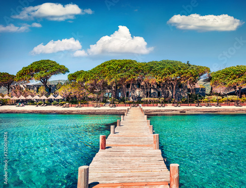 Magnificent summer view of wooden pier on Santa Giulia beach. Romantic morning scene of Corsica island, France, Europe. Splendit Mediterranean seascape. Beauty of nature concept background.. photo