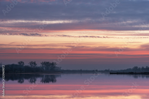 Landscape evening with sunset on a lake with lilies, with beautiful sky in summer season 