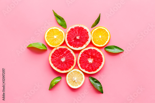 Fototapeta Naklejka Na Ścianę i Meble -  Citrus pattern. Lemon and grapefruits slices and leaves on pink background top-down