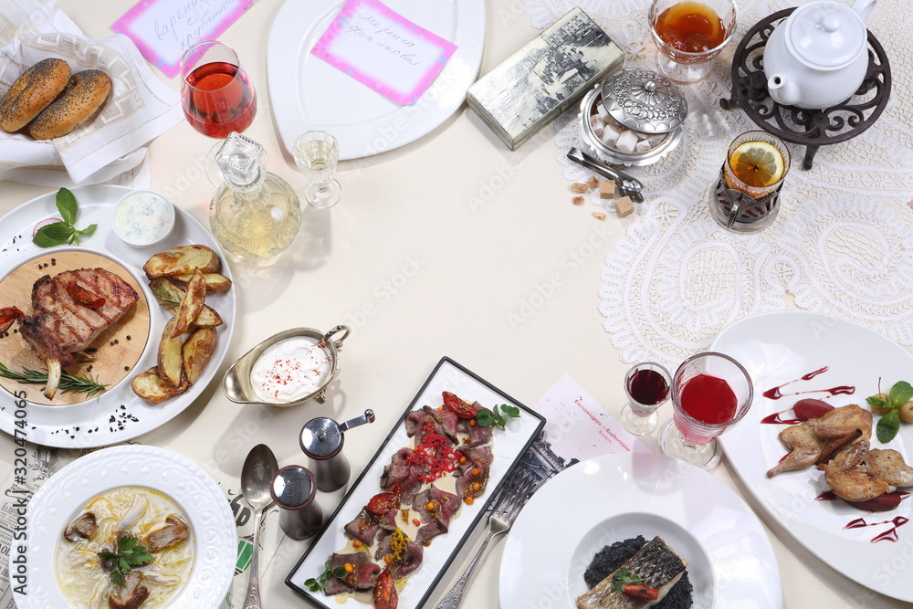 Served table in the restaurant. Mushroom soup, meat plate, steak with potatoes and tea with dessert