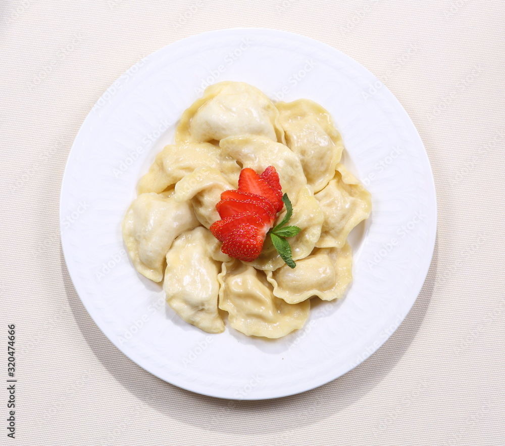 Dumplings with strawberries on a white plate Dumplings with strawberries on a white plate