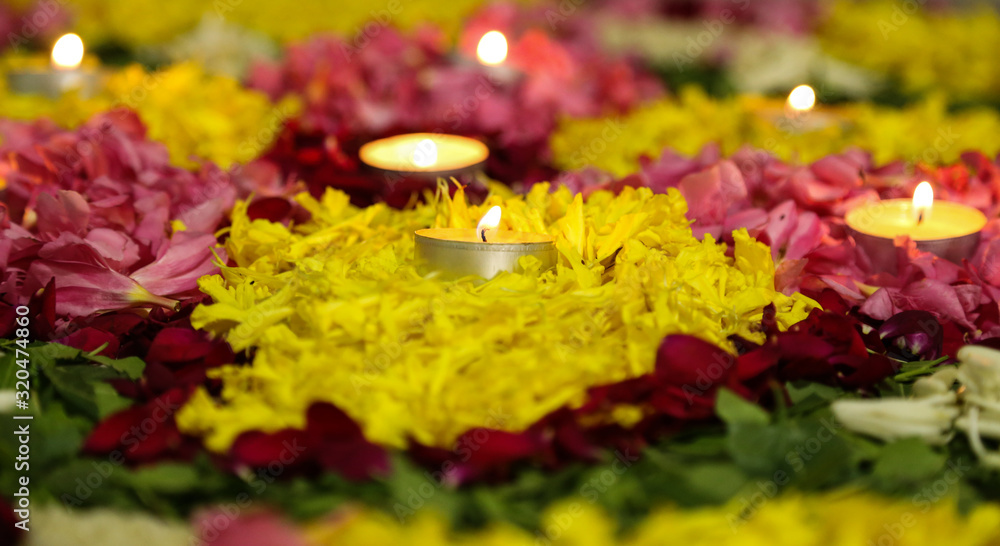 Flower rangoli designs and decoration with candle light for Diwali or Pongal or Onam during different Indian festive seasons Flower rangoli designs and decoration with candle light for Diwali or Pongal or Onam during different Indian festive seasons