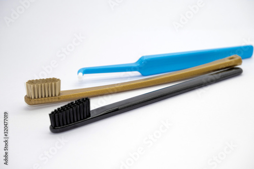   olored gold  black and blue different toothbrushes for different purposes on a light background