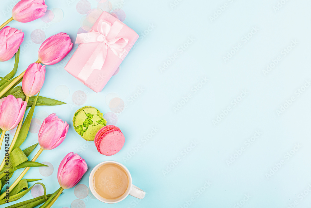 View from above tulips and gift box with copy space on blue. Background for womens day, 8 March Valentine's day, 14 february. Flat lay style, top view, mockup, template, overhead. Greeting card View from above tulips and gift box with copy space on blue. Background for womens day, 8 March Valentine's day, 14 february. Flat lay style, top view, mockup, template, overhead. Greeting card